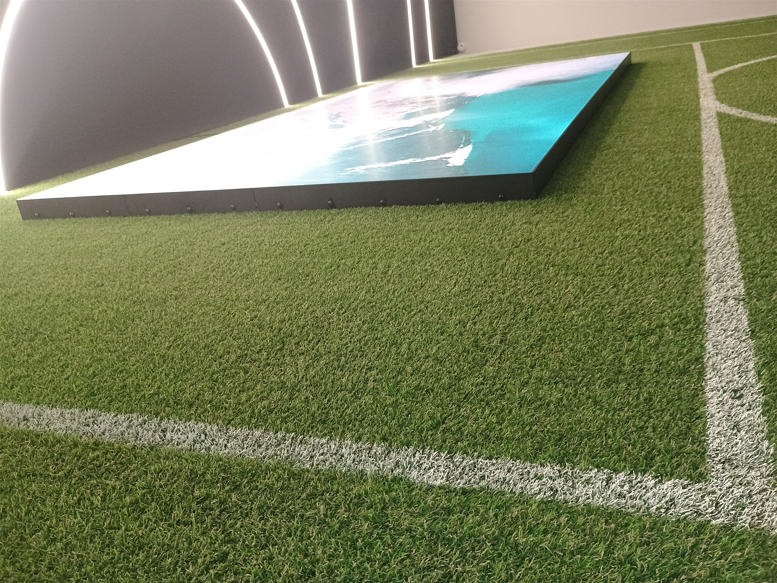 Painel de LED ligado visto em ângulo lateral no ambiente esportivo da Casa Centauro