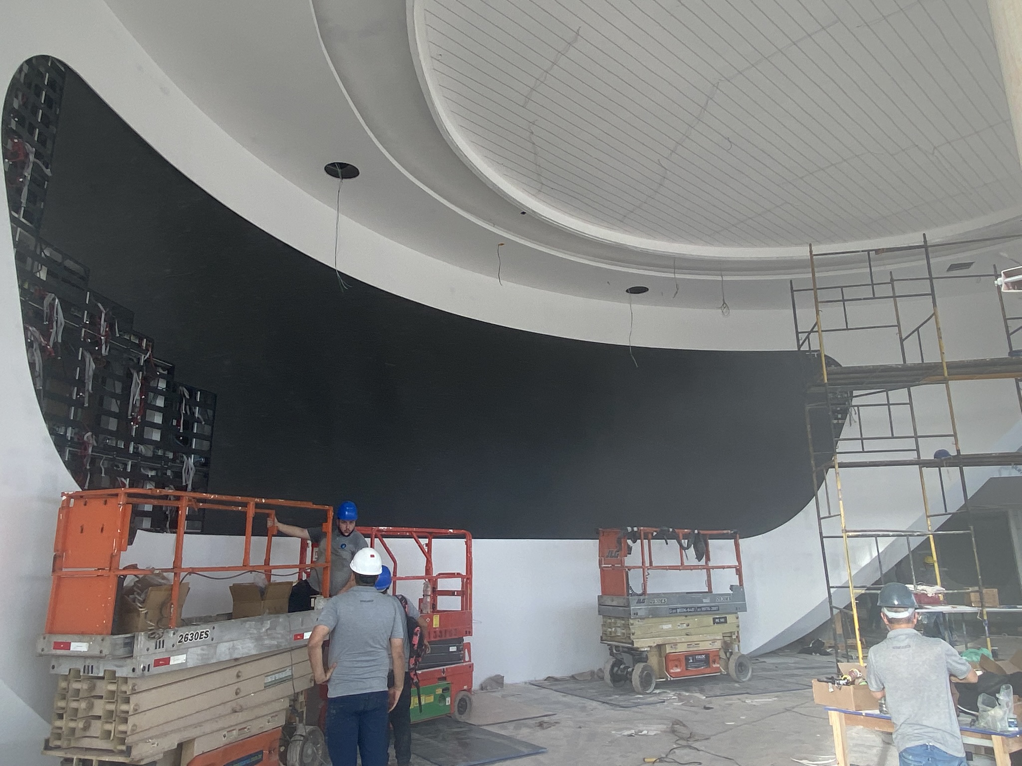 Vista ampla do painel de LED curvo em formato orgânico durante a montagem no showroom