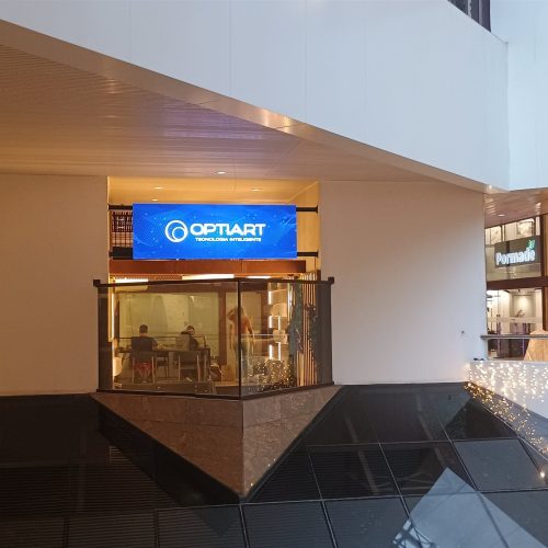Painel de LED horizontal instalado acima da fachada de uma loja no atrio do Shopping D&D em Sao Paulo