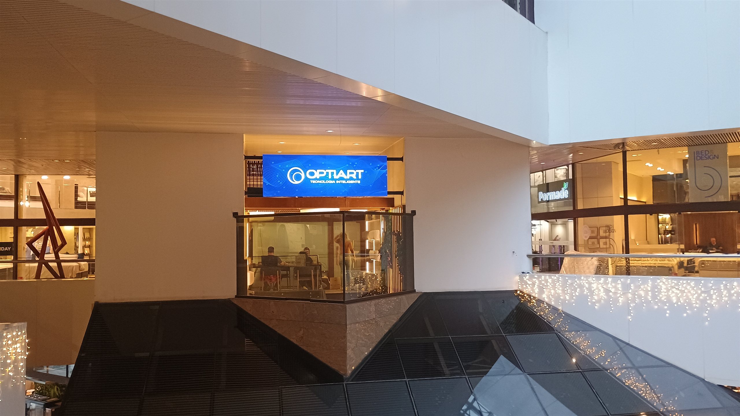 Painel de LED horizontal instalado acima da fachada de uma loja no atrio do Shopping D&D em Sao Paulo