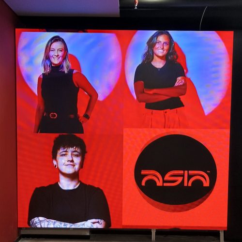 Painel de LED de grande formato ocupando a parede de um ambiente corporativo, exibindo identidade visual da marca