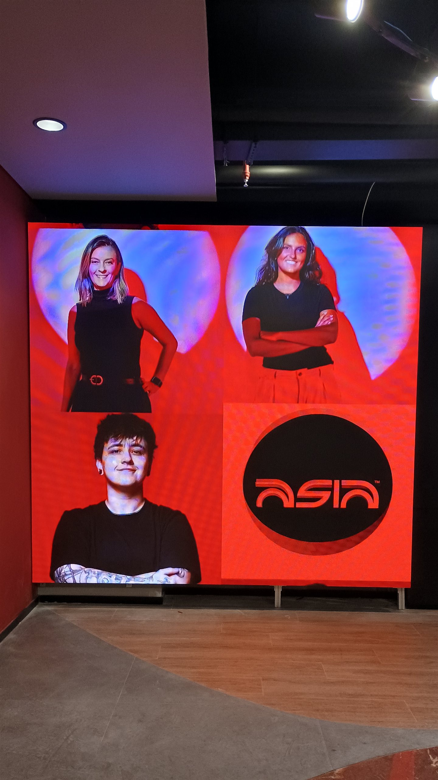 Painel de LED de grande formato ocupando a parede de um ambiente corporativo, exibindo identidade visual da marca