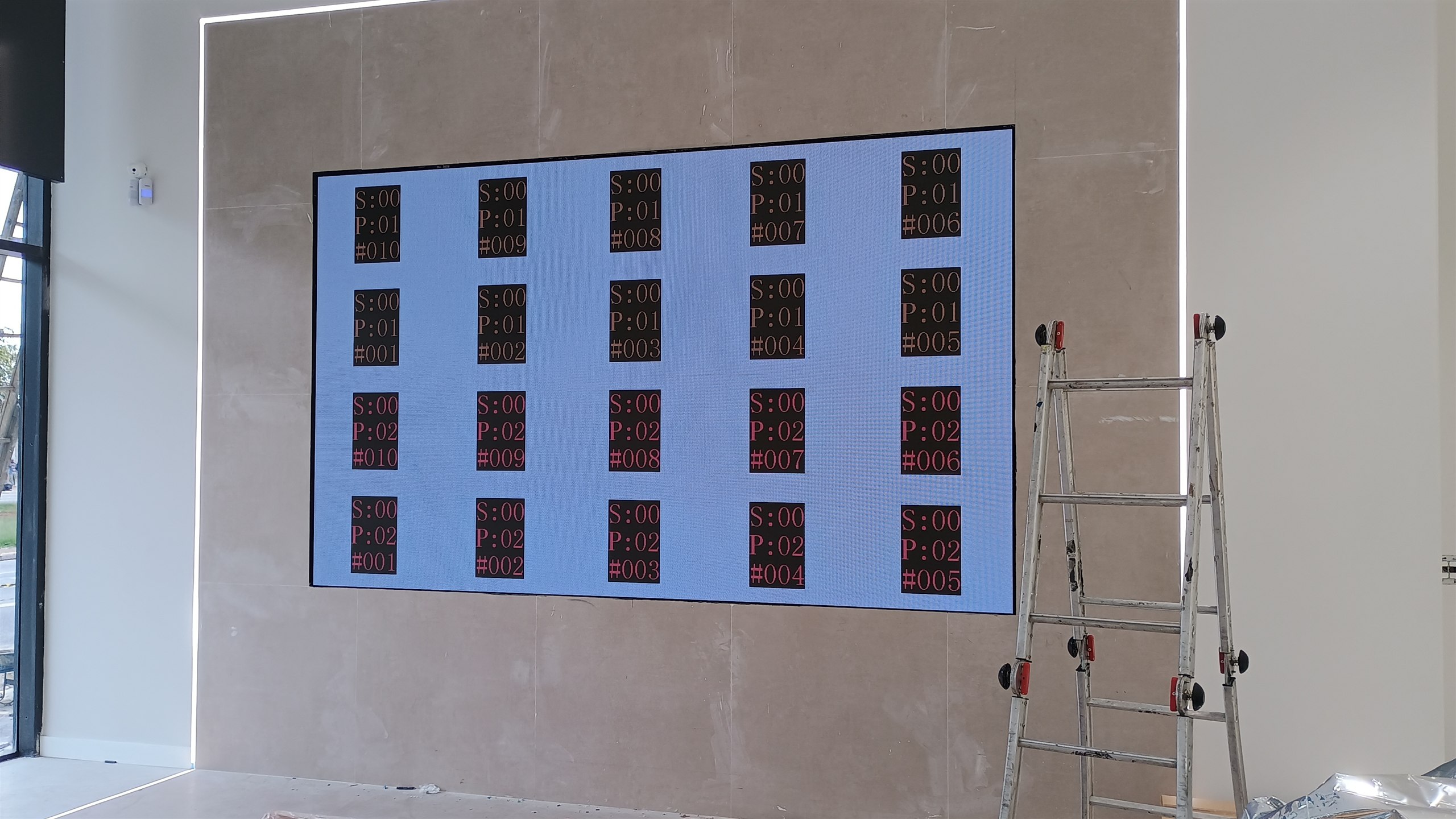 Painel de LED ligado exibindo padrão de teste de mapeamento durante a instalação no showroom