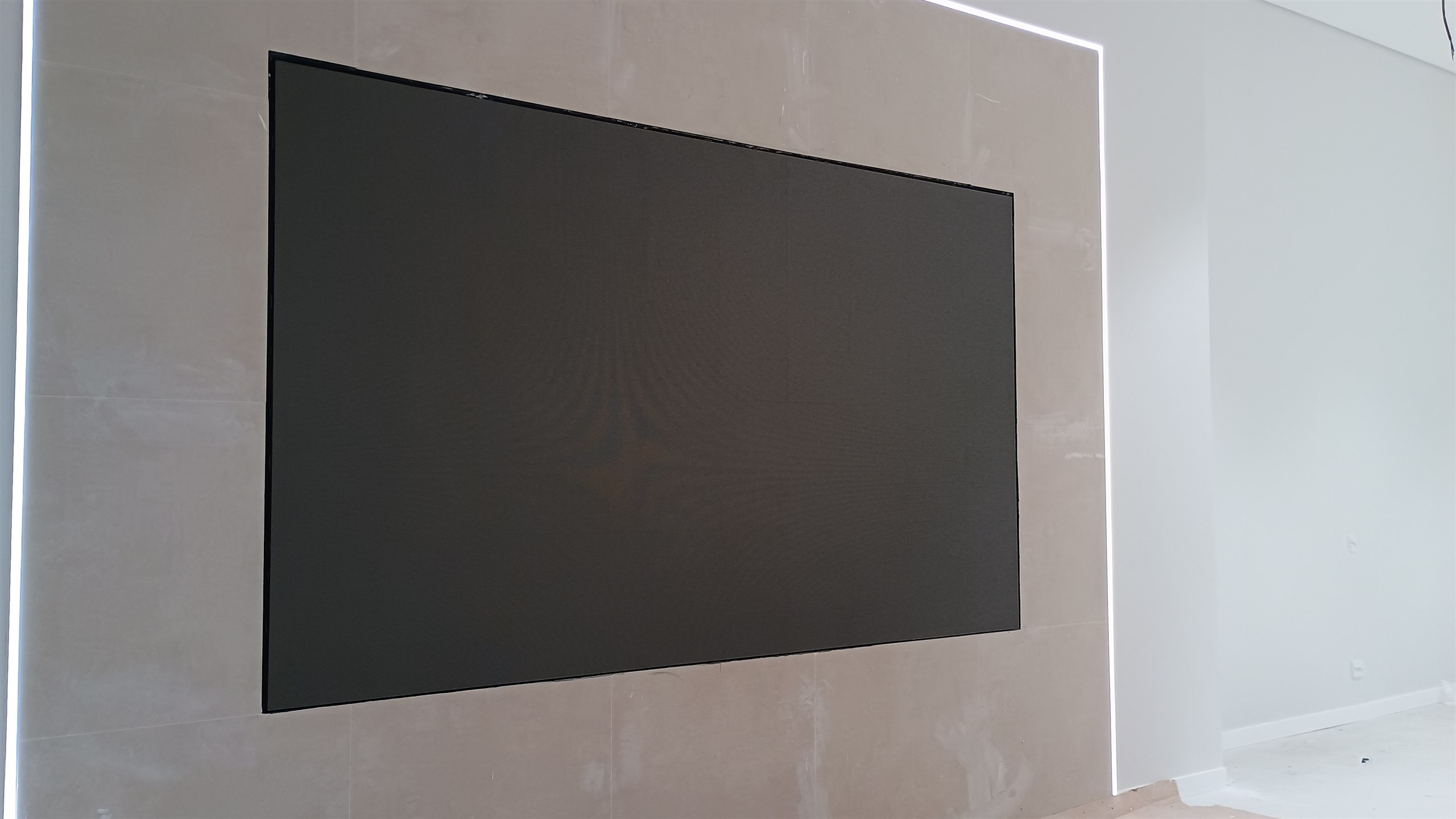 Painel de LED embutido na parede do showroom, emoldurado por iluminação de LED