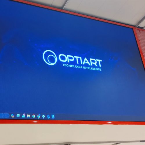 Painel de LED aceso instalado na testeira da loja Centauro no Shopping Morumbi, exibindo a marca Optiart