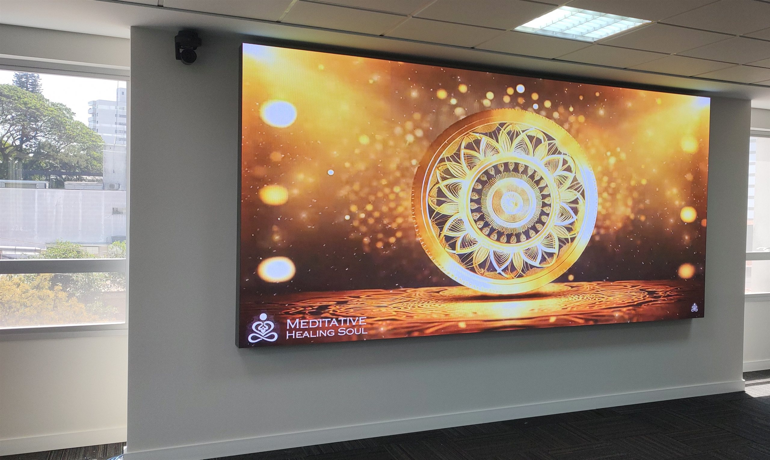 Painel de LED fine pitch P1.8 instalado em parede de ambiente corporativo, exibindo conteÃºdo grÃ¡fico dourado em alta definiÃ§Ã£o