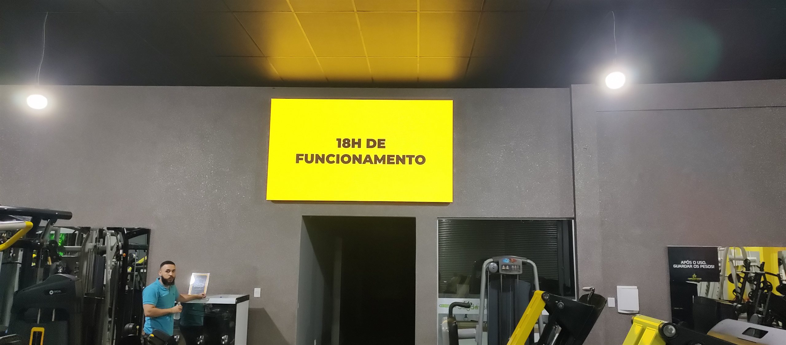Painel de LED instalado em academia exibindo conteudo motivacional, projeto Optiart