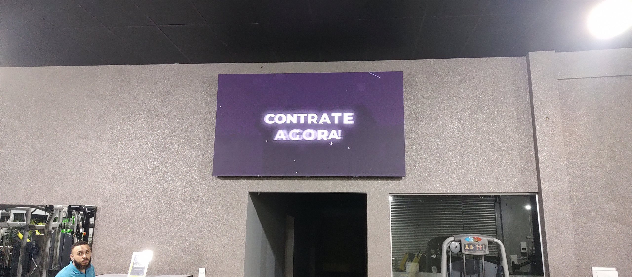 Painel de LED em academia exibindo mensagem promocional, solucao Optiart