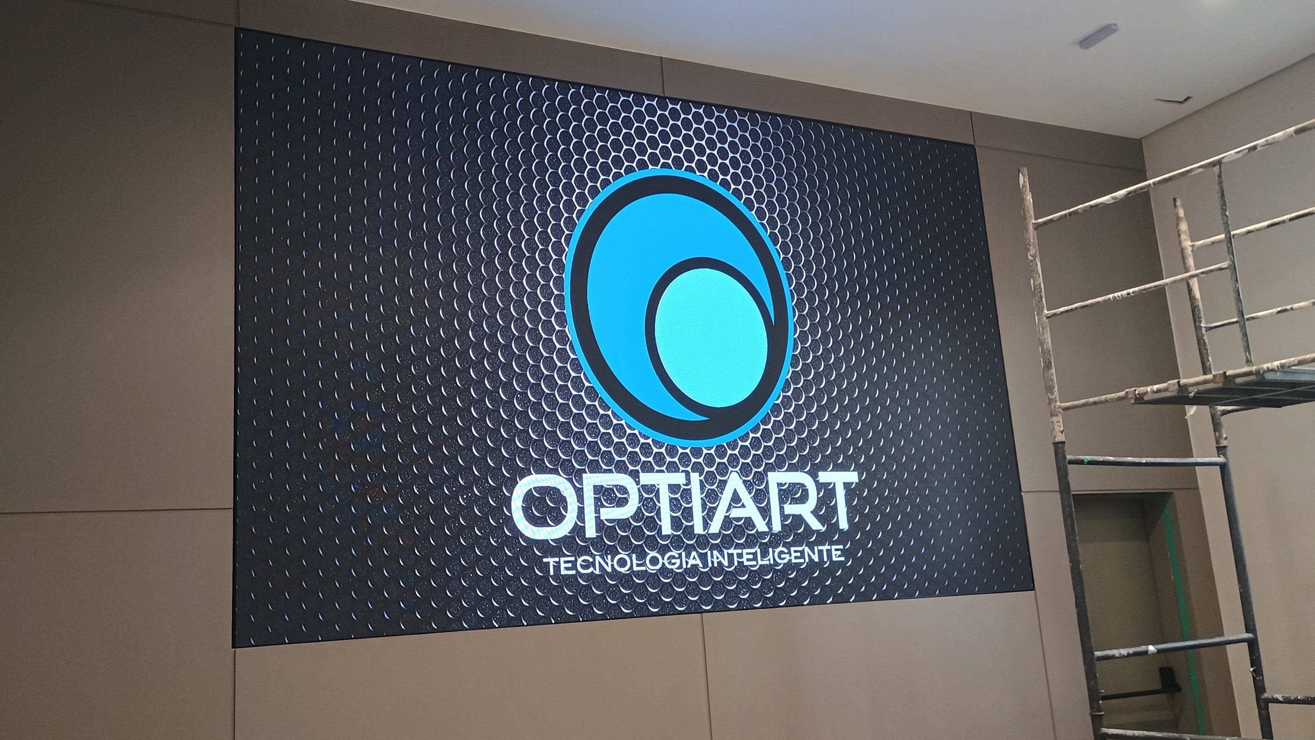 Painel de LED indoor exibindo logotipo da Optiart sobre fundo escuro texturizado