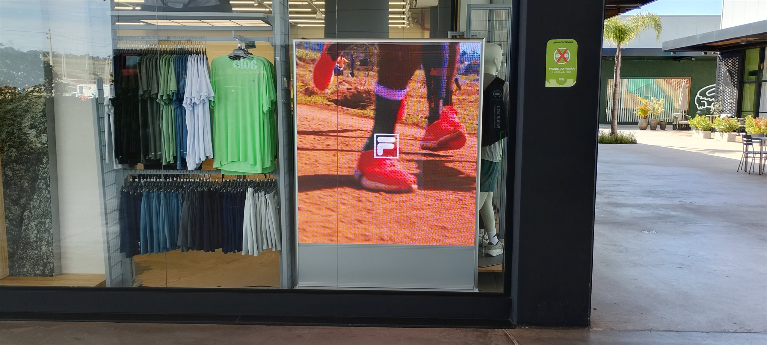 Painel de LED em outlet esportivo exibindo conteudo de corrida em pista