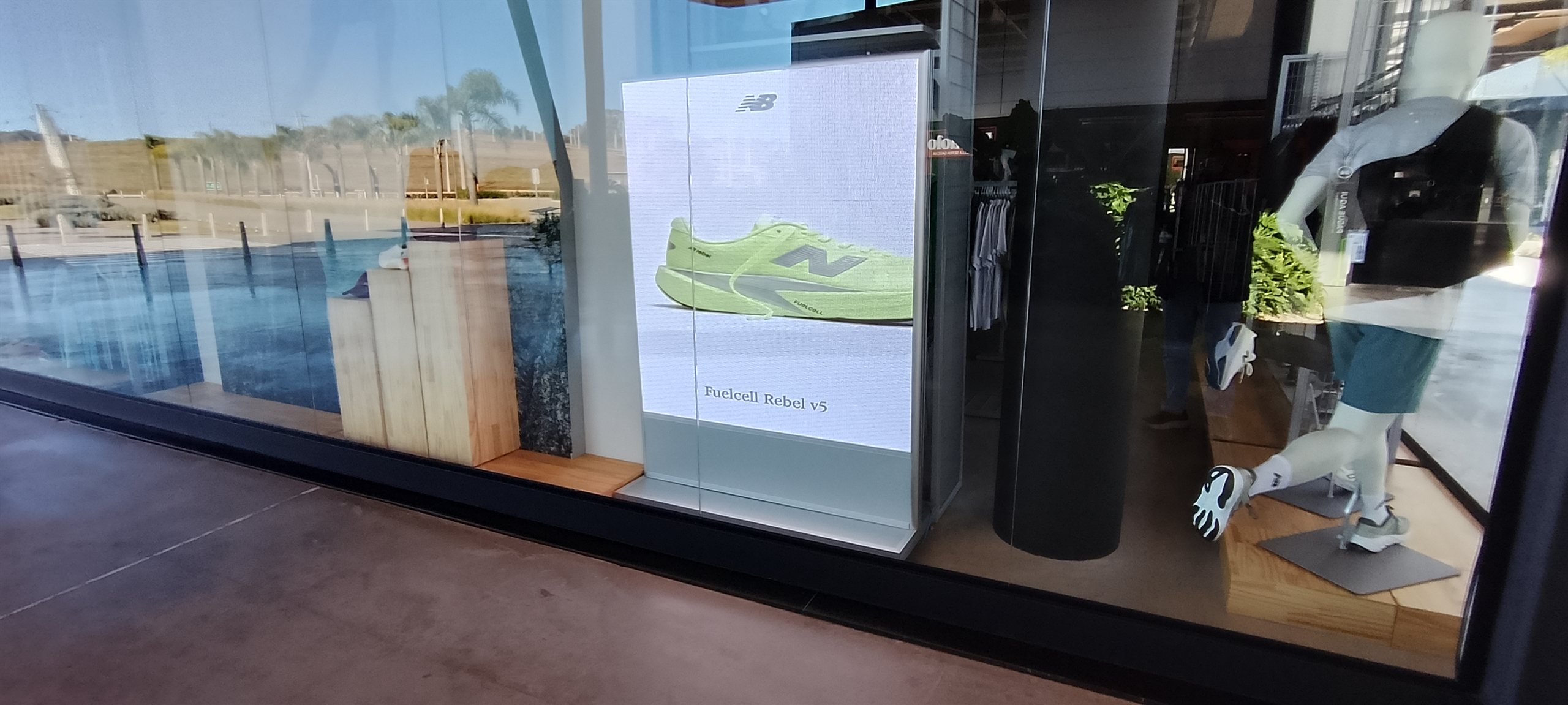 Painel de LED indoor exibindo tenis de corrida na vitrine de um outlet esportivo