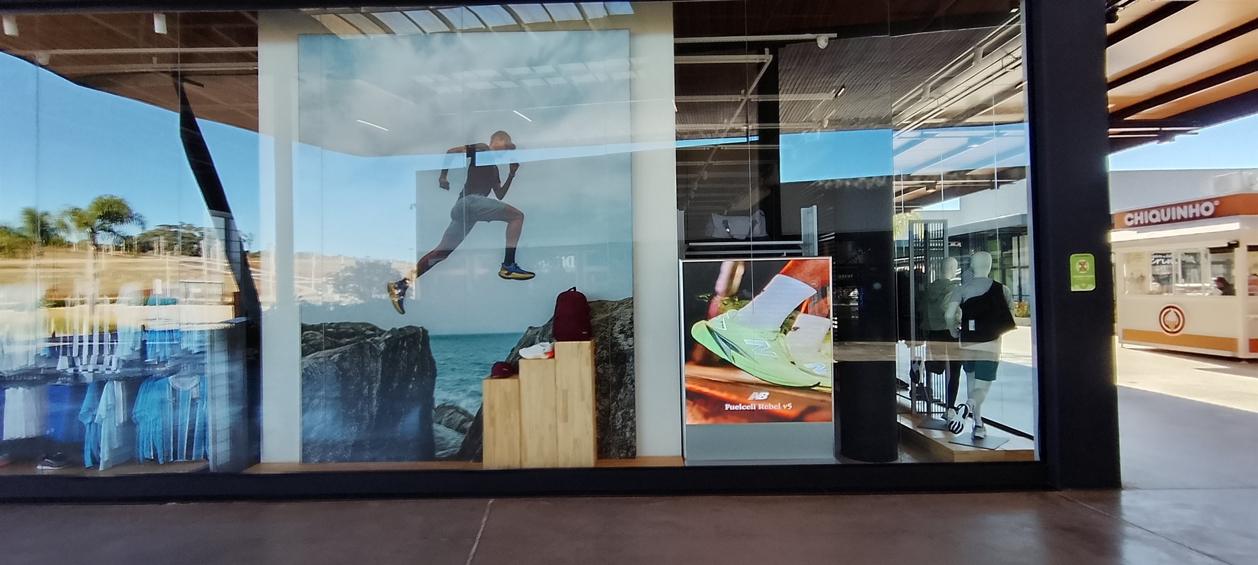 Vitrine de outlet esportivo com painel de LED e visual de produtos esportivos
