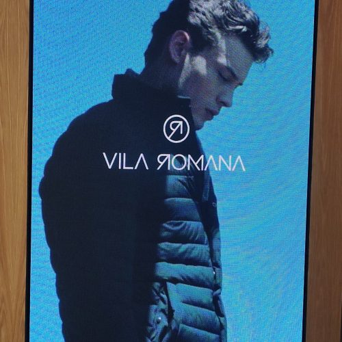 Painel de LED da Optiart na loja Vila Romana exibindo campanha de moda masculina com a marca Vila Romana