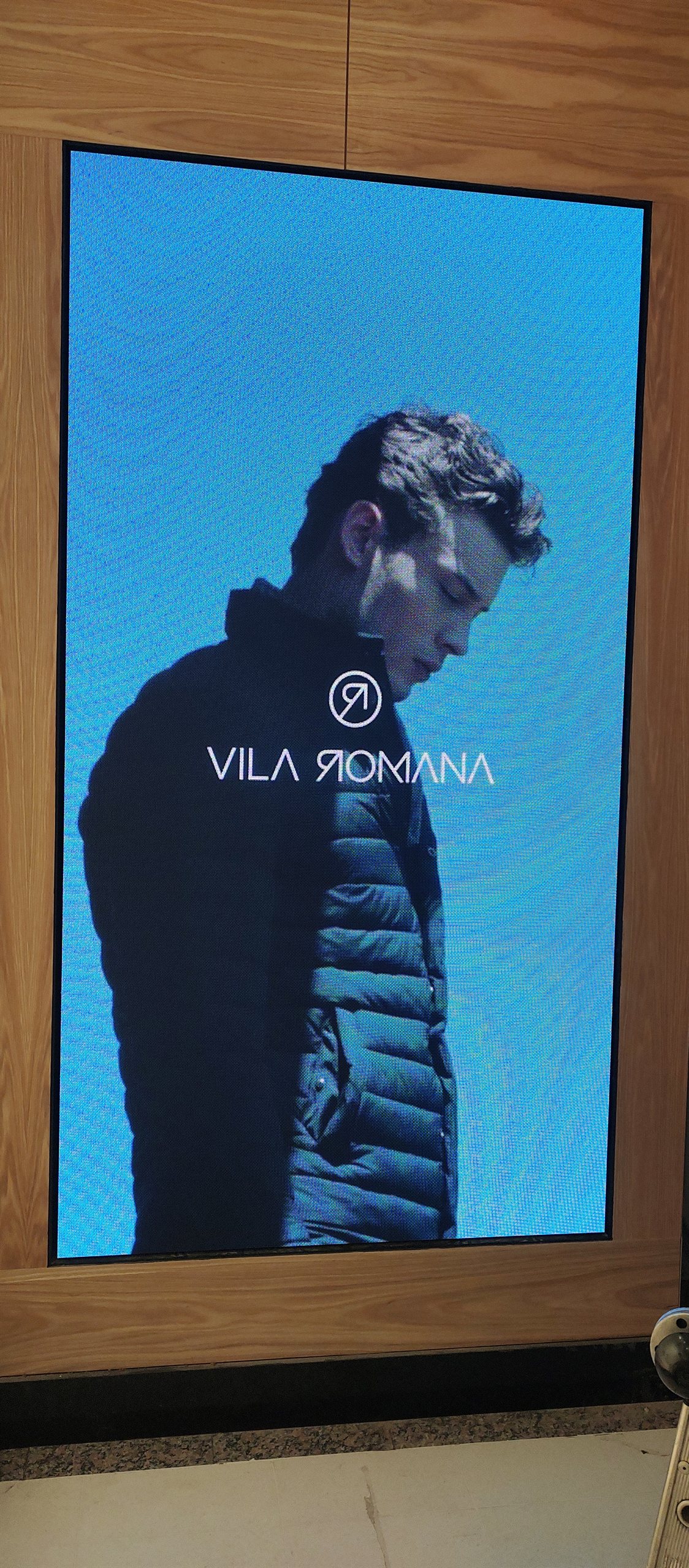Painel de LED da Optiart na loja Vila Romana exibindo campanha de moda masculina com a marca Vila Romana