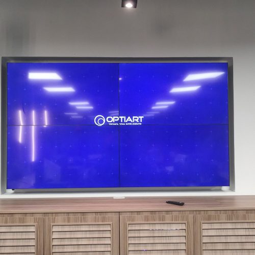VideoWall 2x2 ligado sobre móvel de madeira no escritório da Prudential em Botafogo, Rio de Janeiro