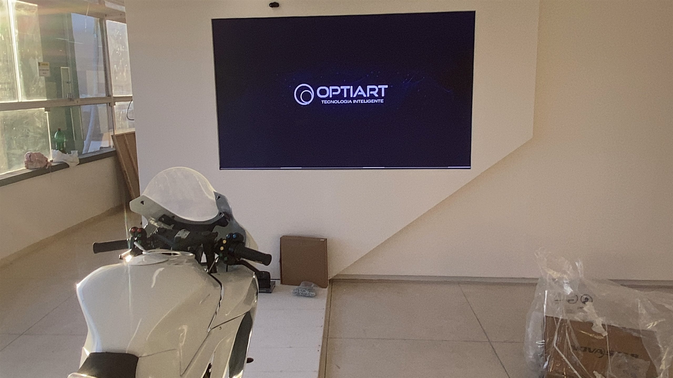 Simulador de motocicleta em frente ao painel de LED P1.8 da exposição interativa do Museu do Esporte