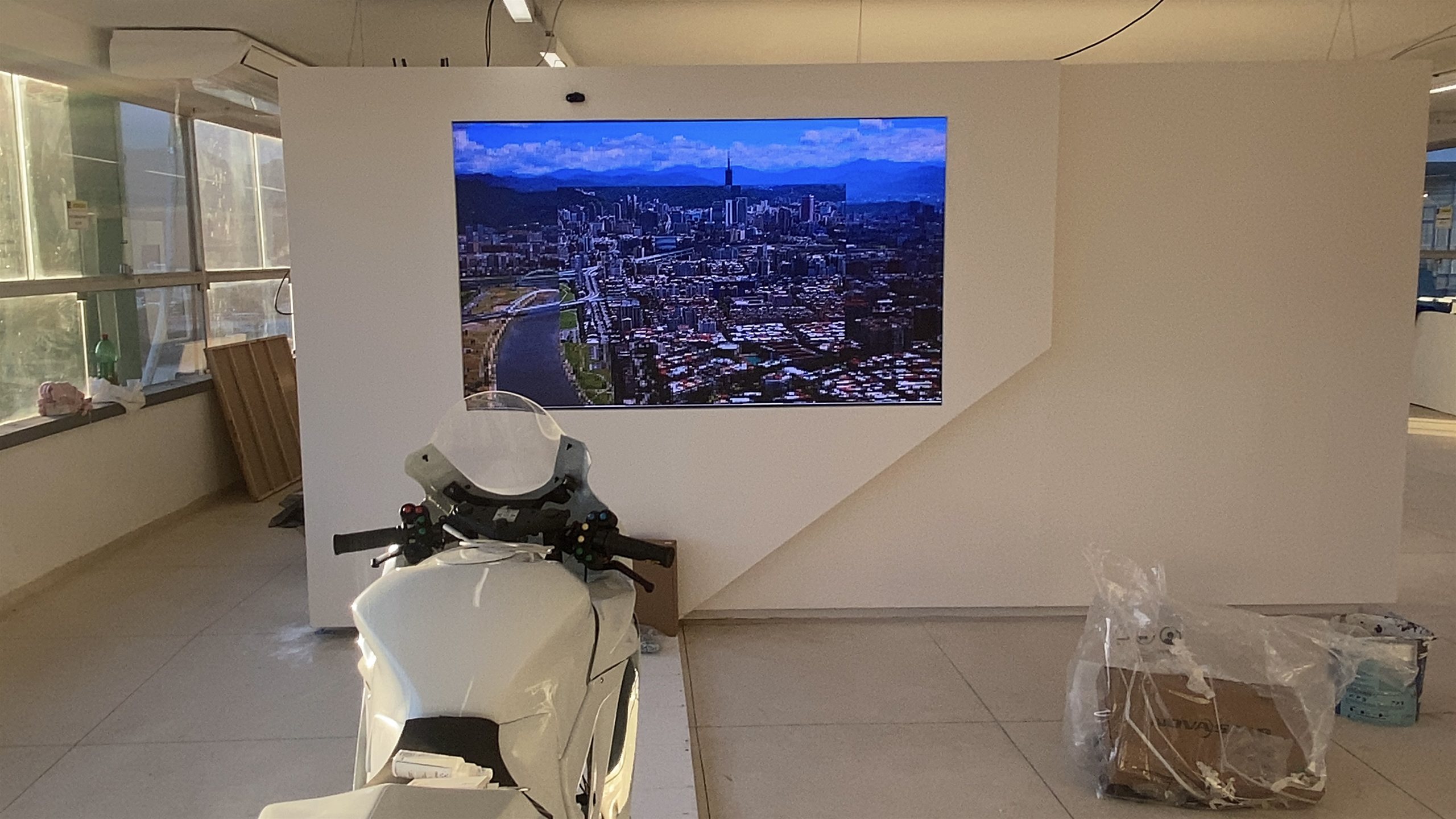 Painel de LED P1.8 embutido em parede cenográfica exibindo vídeo aéreo de cidade no Museu do Esporte, no Rio de Janeiro