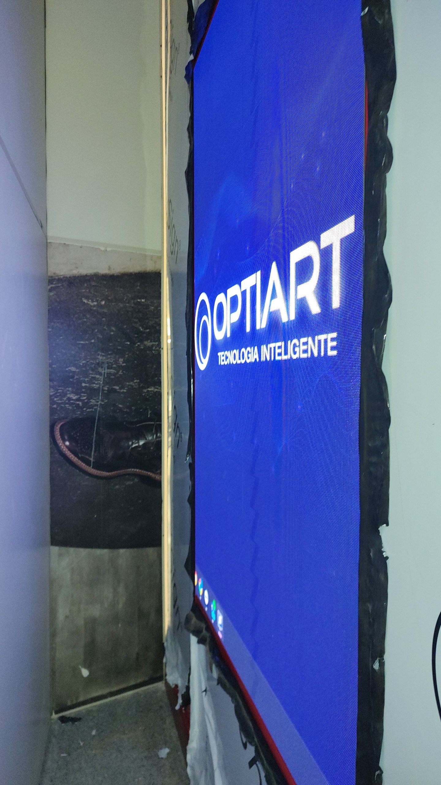 Painel de LED vertical ligado durante o comissionamento da instalação no Shopping Eldorado, exibindo a tela de abertura da Optiart