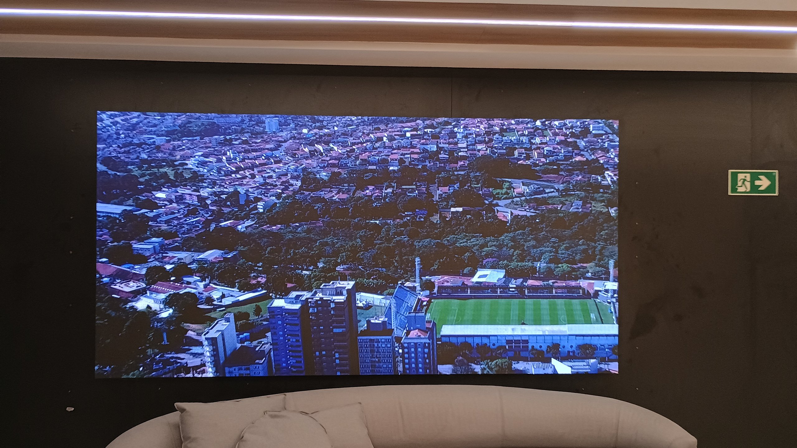 Painel de LED na recepcao do centro de treinamento do Red Bull Bragantino exibindo imagem aerea do estadio