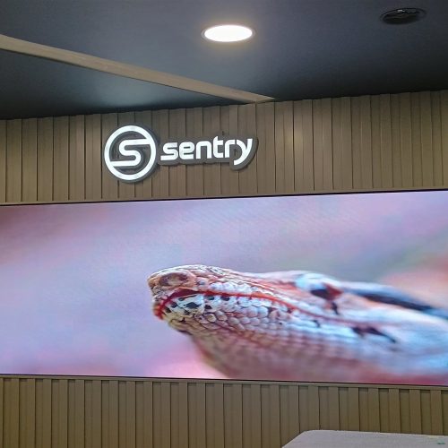 Painel de LED P1.2 de 5,40 x 1,35 m exibindo video em sala de monitoramento