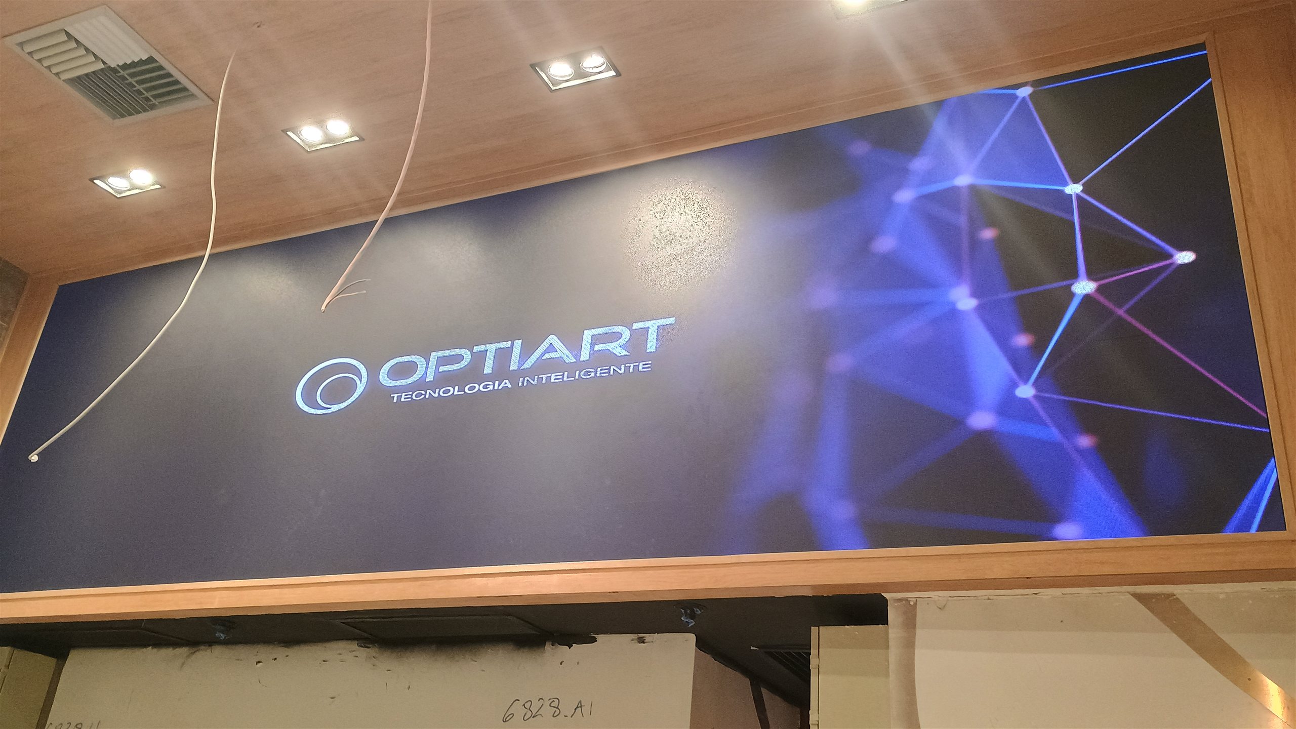 Painel de LED indoor de 4,16 x 1,28 m ligado, embutido na marcenaria acima da area de atendimento da loja
