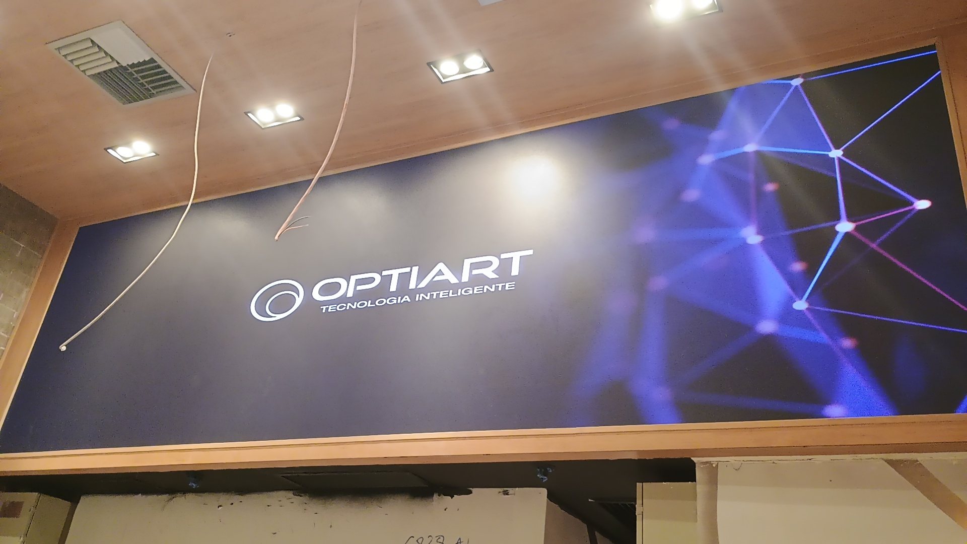 Painel de LED P2.5 embutido em nicho de marcenaria de loja em shopping, ligado com conteudo institucional