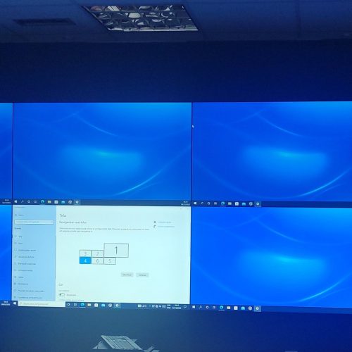 VideoWall 2x4 com oito monitores de 55 polegadas instalado na sala de controle de um data center, ocupando a largura da parede frontal