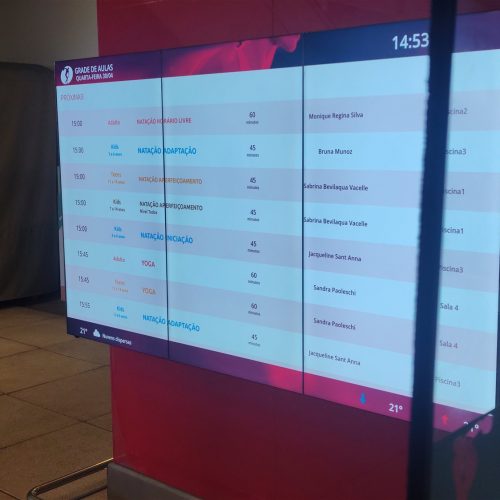 VideoWall 1x3 vertical exibindo grade de aulas em tempo real na Cia Athletica do Open Mall The Square