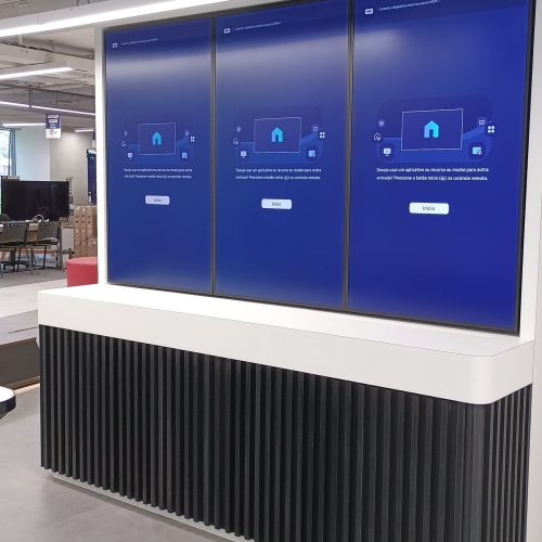 VideoWall 1x3 vertical com três monitores Samsung ligados sobre móvel em loja de grande varejo na Berrini, São Paulo