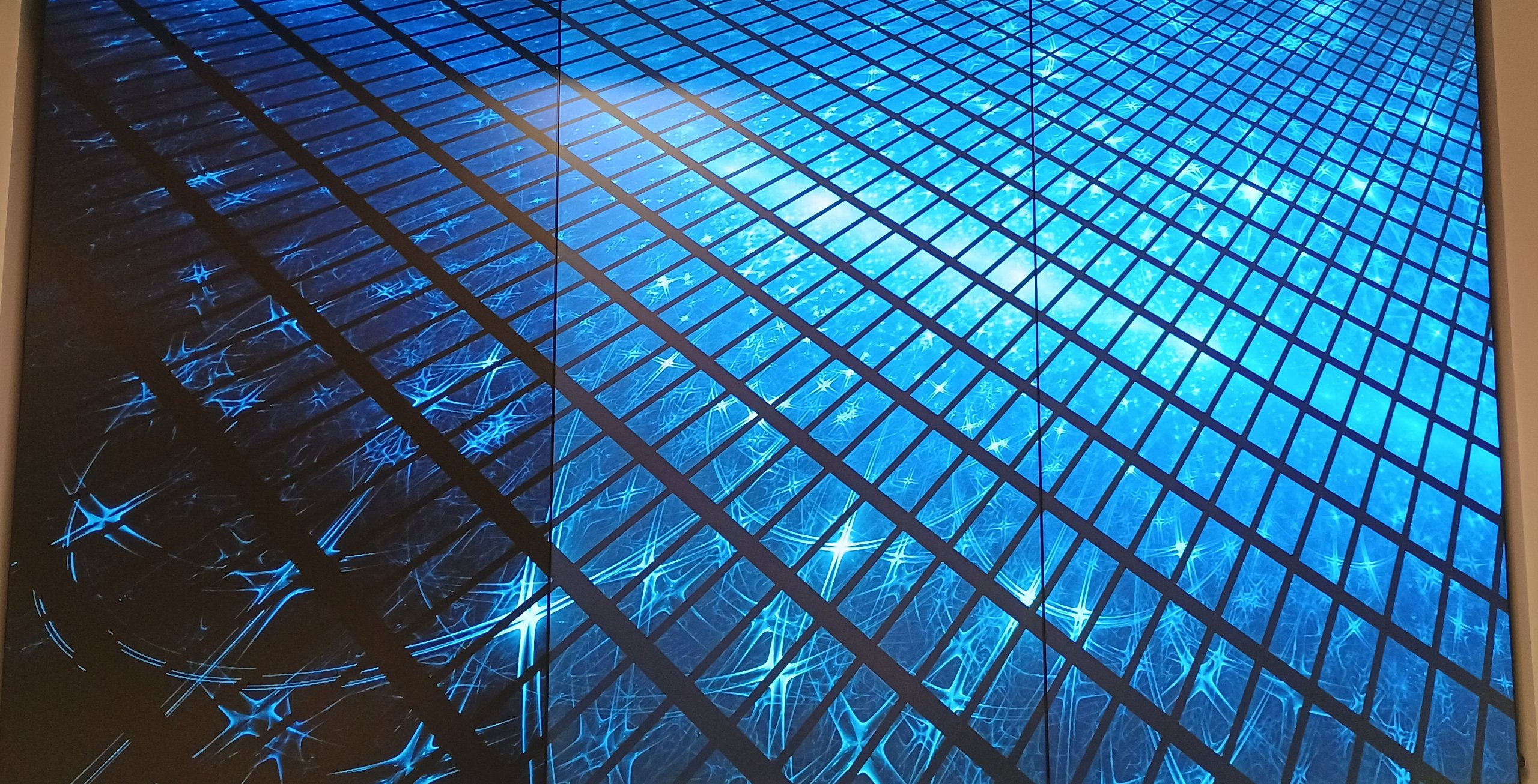 VideoWall 1x3 vertical embutido em nicho na parede exibindo conteúdo digital em tela cheia na Prudential Curitiba Hunters
