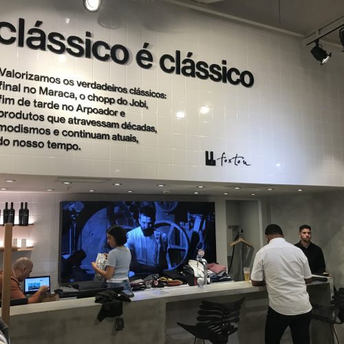 Parede da loja Foxton no BarraShopping com letreiro clássico é clássico e VideoWall 1x4 vertical exibindo vídeo da marca