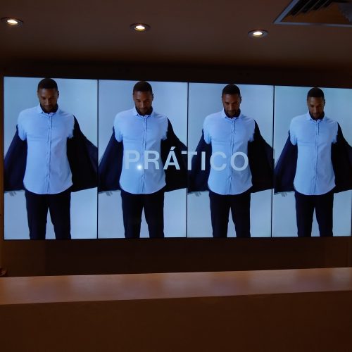 VideoWall 1x4 vertical na loja Foxton Icaraí em Niterói exibindo campanha de moda masculina com quatro monitores em pé lado a lado
