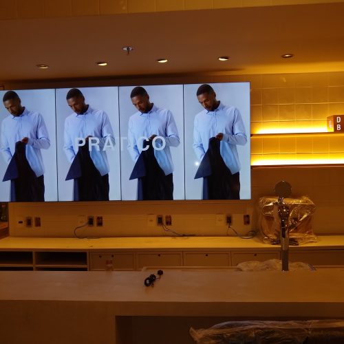 VideoWall 1x4 vertical exibindo campanha PRÁTICO da Foxton na loja Savassi, ao lado do letreiro Design Bar
