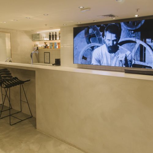 Balcão Design Bar da loja Foxton no Shopping JK com VideoWall 1x4 vertical exibindo vídeo em preto e branco