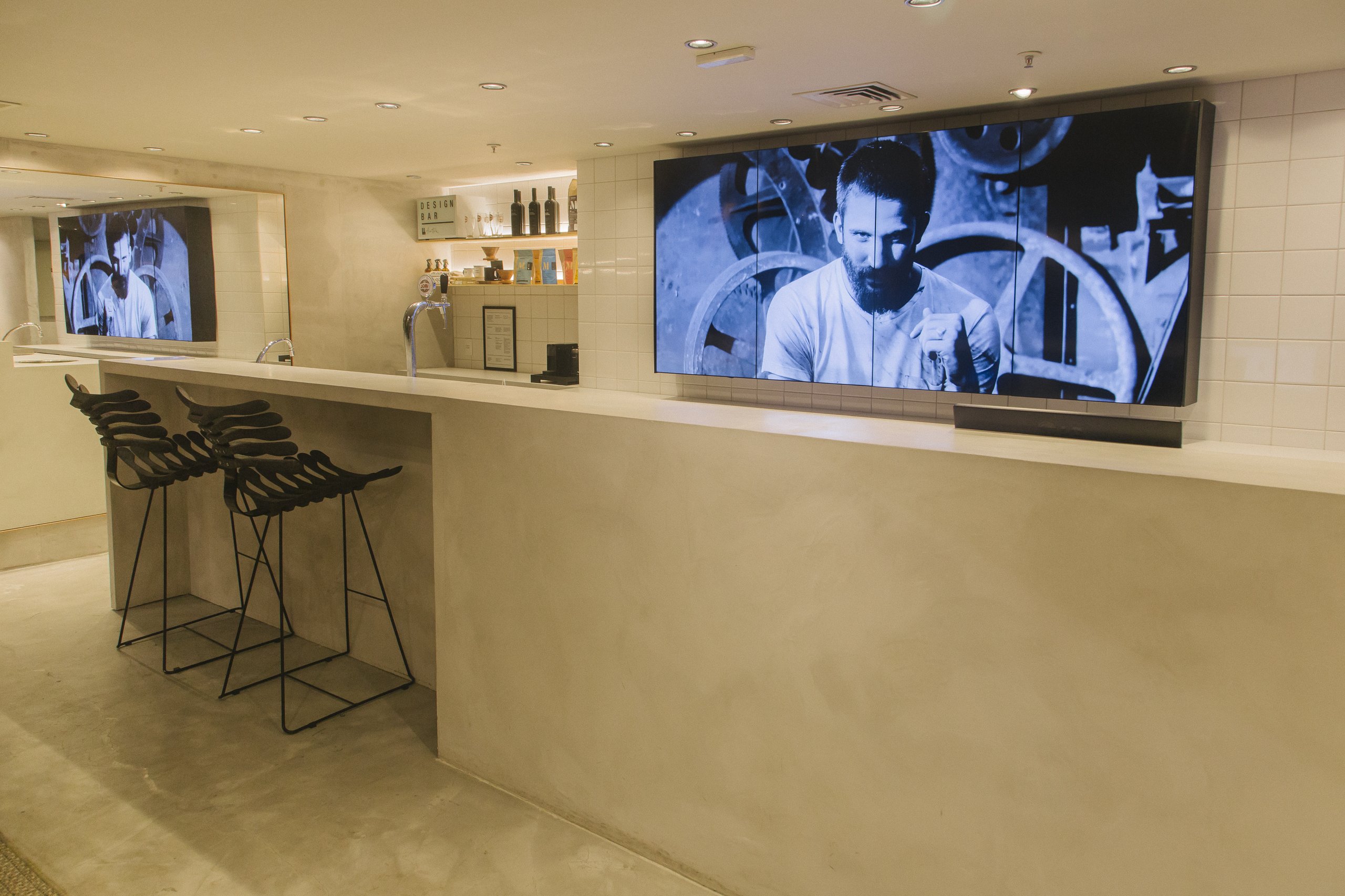Balcão Design Bar da loja Foxton no Shopping JK com VideoWall 1x4 vertical exibindo vídeo em preto e branco