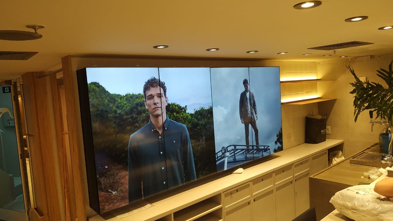 VideoWall 1x4 vertical com campanha de moda masculina exibida sobre o balcão da loja Foxton na Tijuca