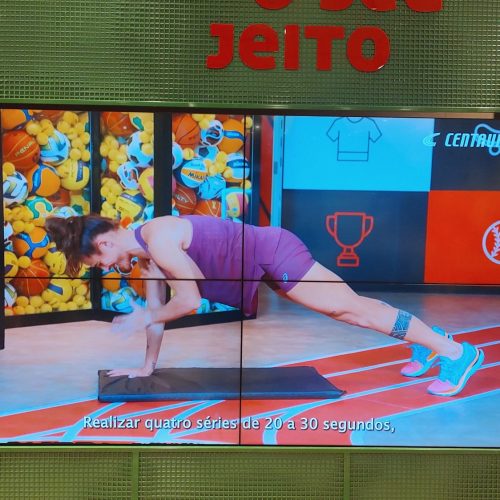 VideoWall 2x2 exibindo vídeo de treino da campanha da Centauro em mural verde na loja de Campinas