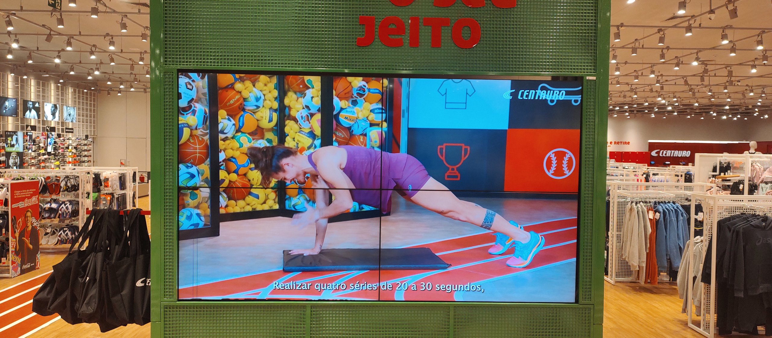 VideoWall 2x2 exibindo vídeo de treino da campanha da Centauro em mural verde na loja de Campinas