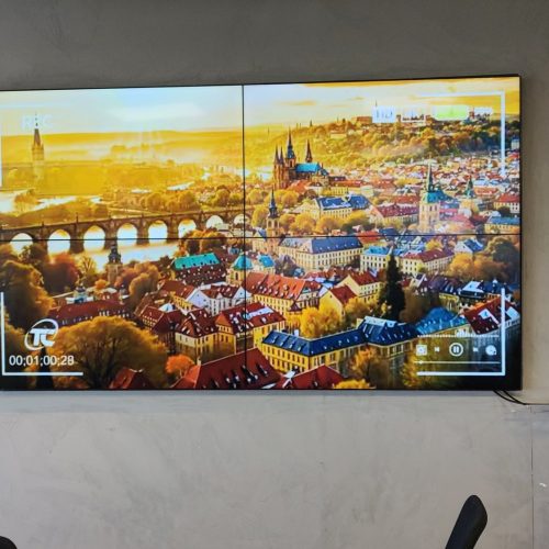 Sala da agência Prudential Star em Nova Lima com VideoWall 2x2 exibindo vídeo de paisagem urbana em tela cheia