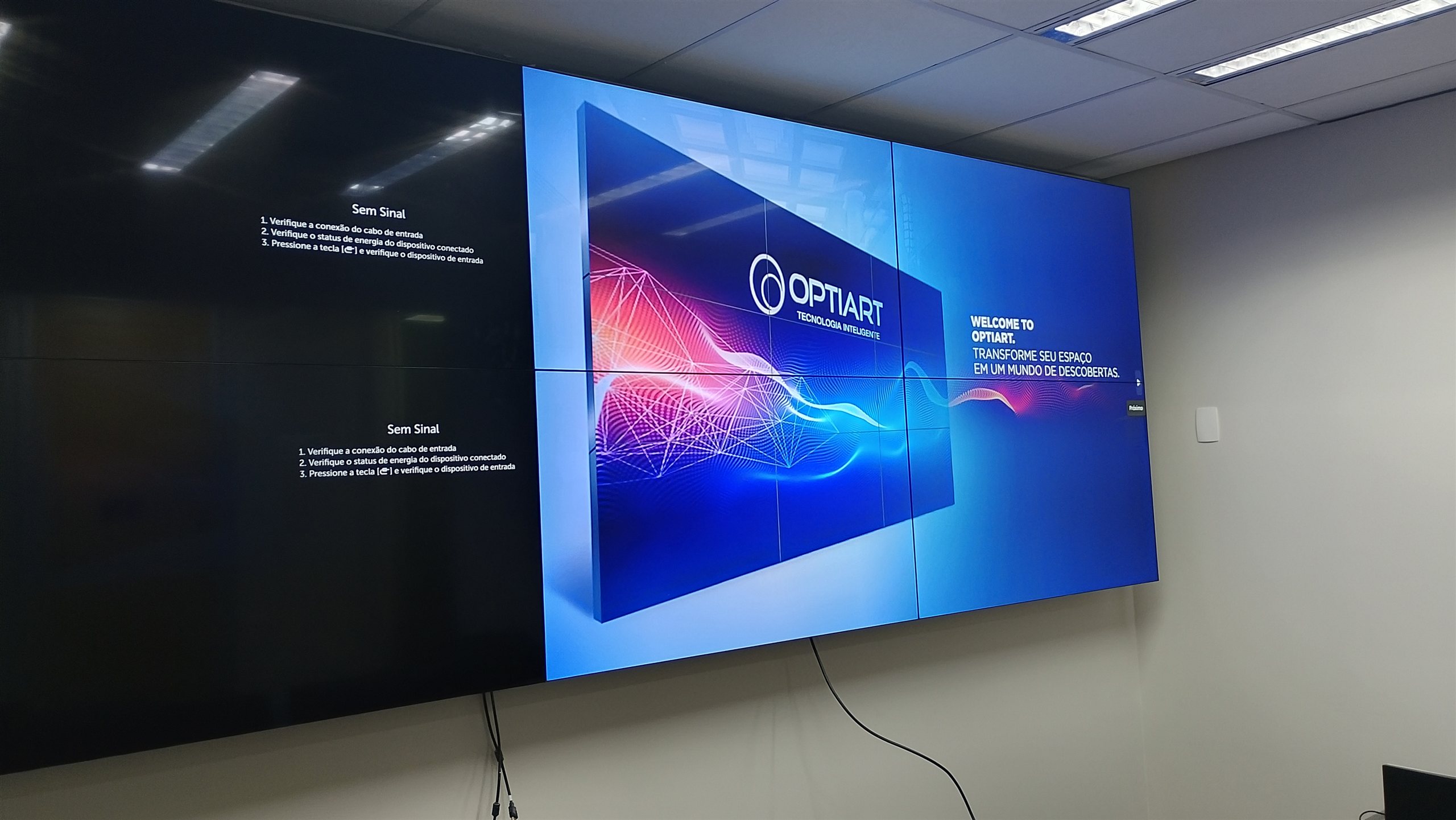 VideoWall 2x4 com monitores LG de 55 polegadas exibindo conteudo institucional em sala de operacao corporativa