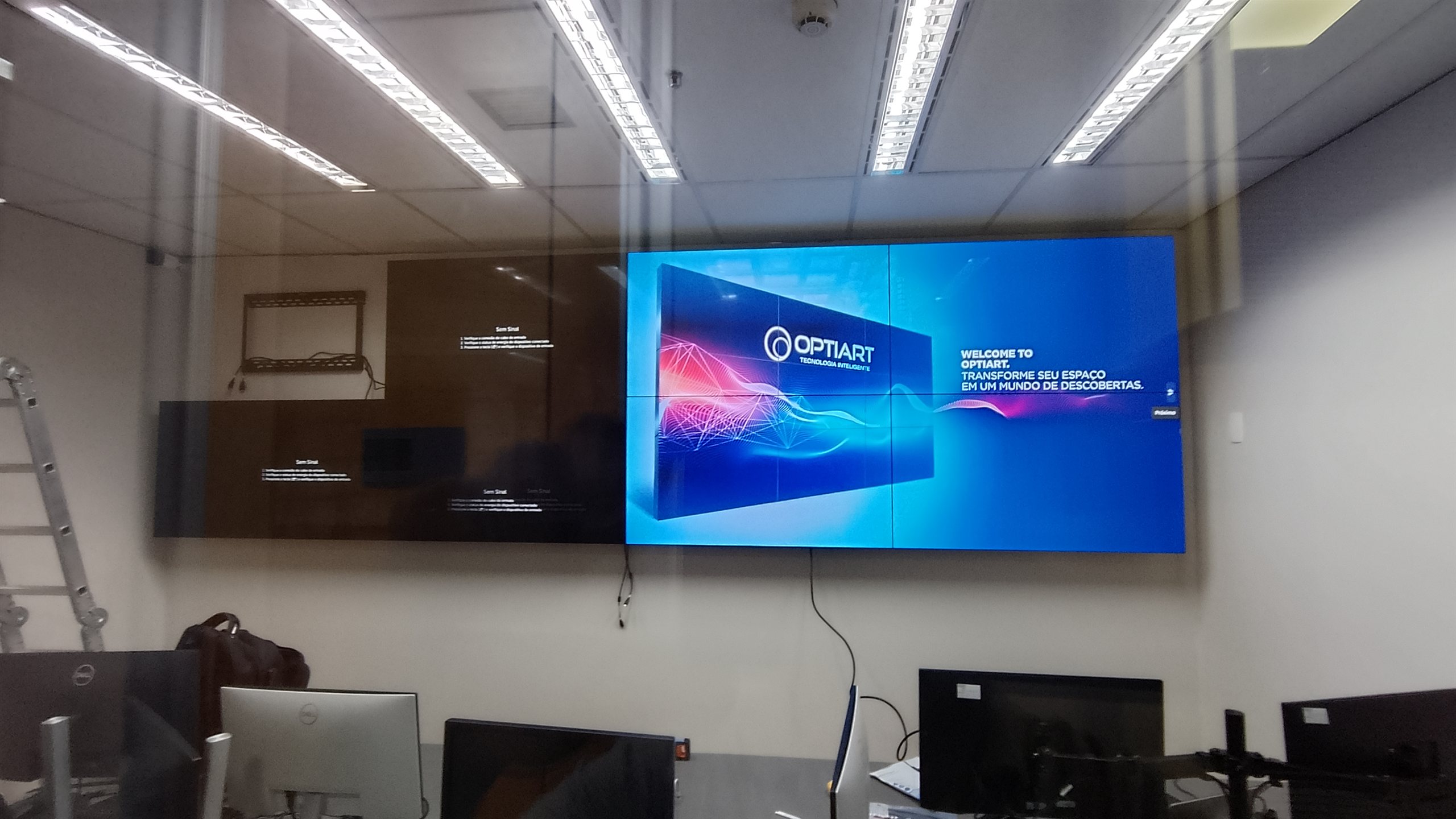 Vista ampla de VideoWall 2x4 instalado em parede de sala de operacao corporativa