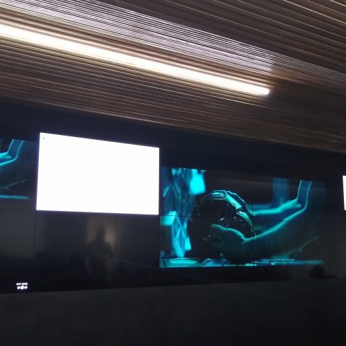 VideoWall 2x6 embutido em nicho exibindo layout multijanela em auditório de centro corporativo