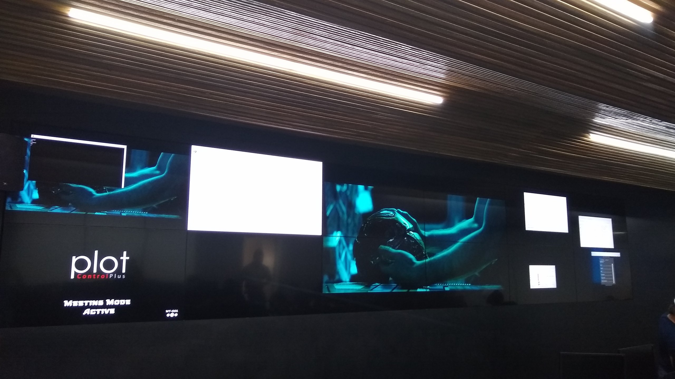 VideoWall 2x6 embutido em nicho exibindo layout multijanela em auditório de centro corporativo