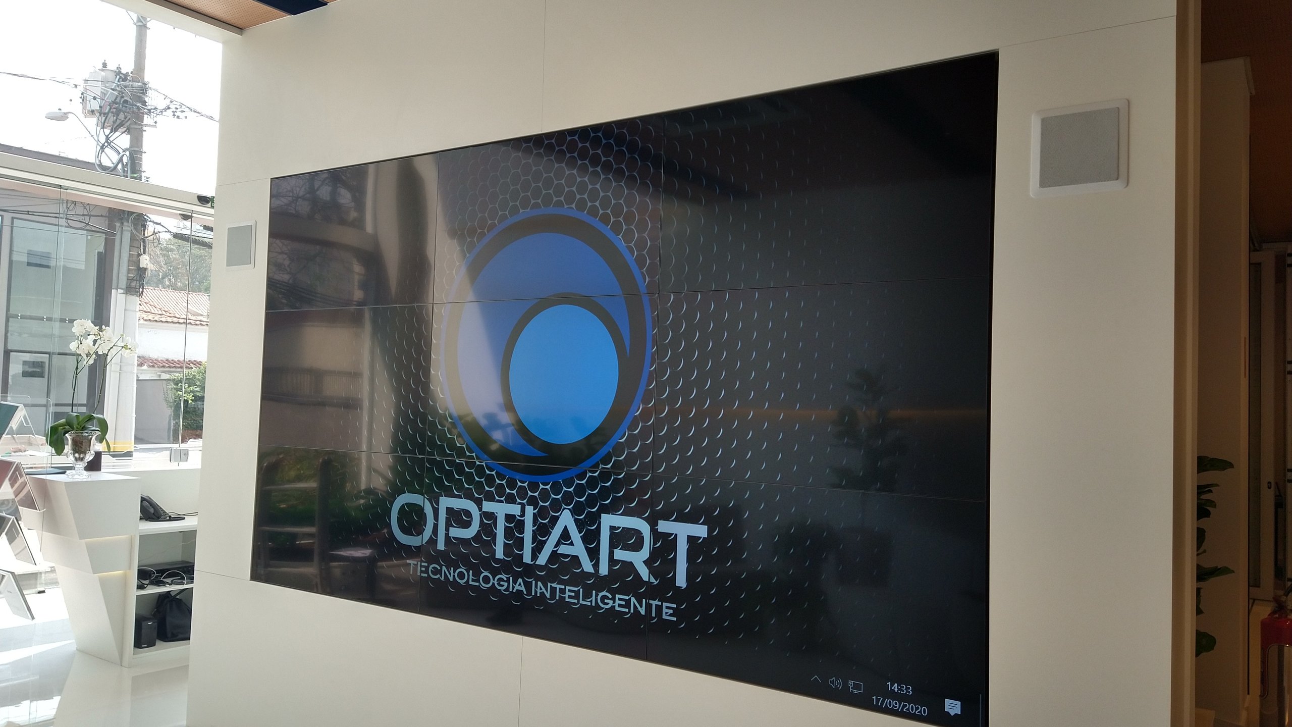 VideoWall 3x3 instalado em nicho na parede do estande de vendas de uma construtora em Campinas, com as nove telas ligadas exibindo conteúdo