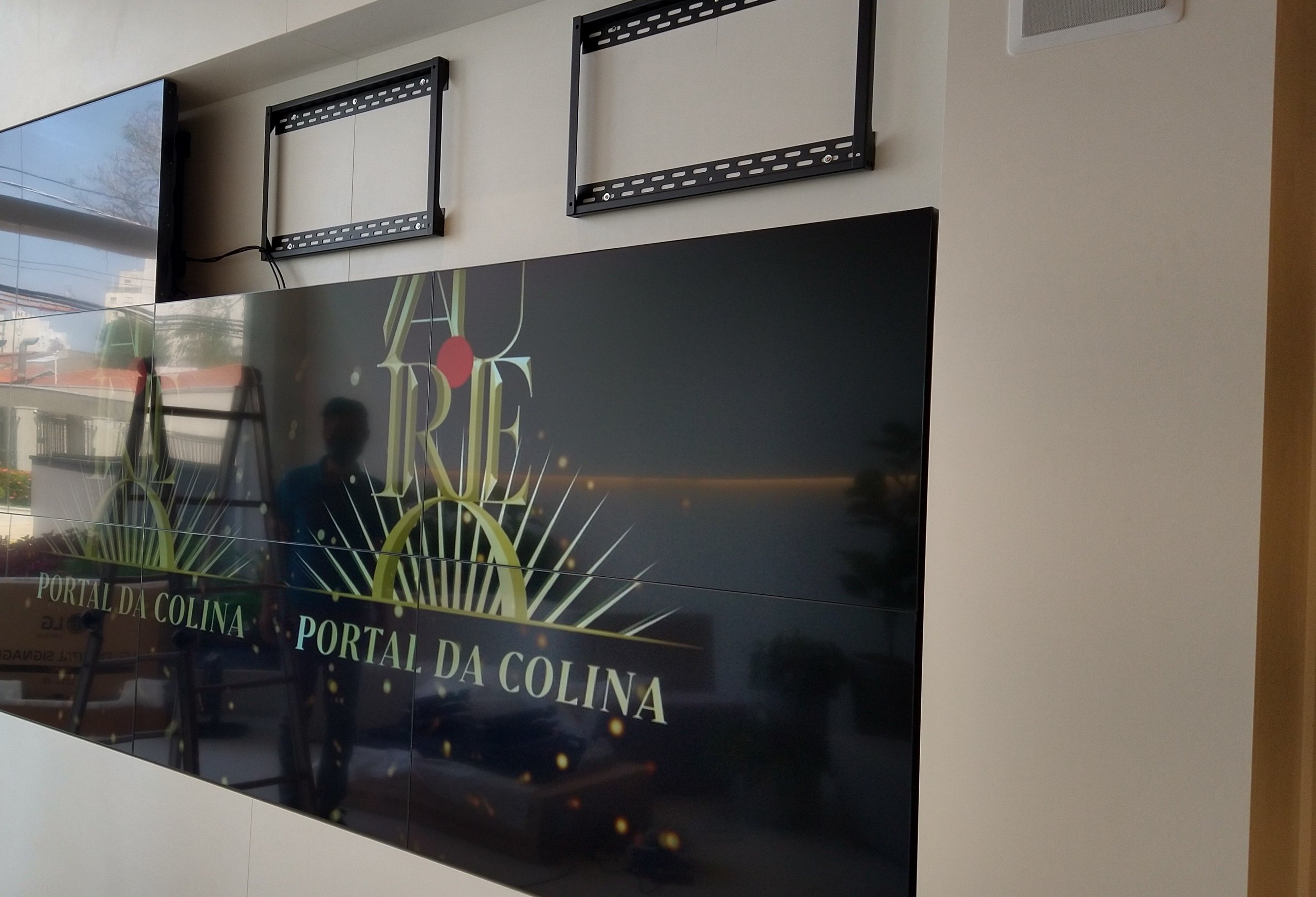 Telas do VideoWall exibindo a identidade visual do empreendimento imobiliário durante a instalação em nicho