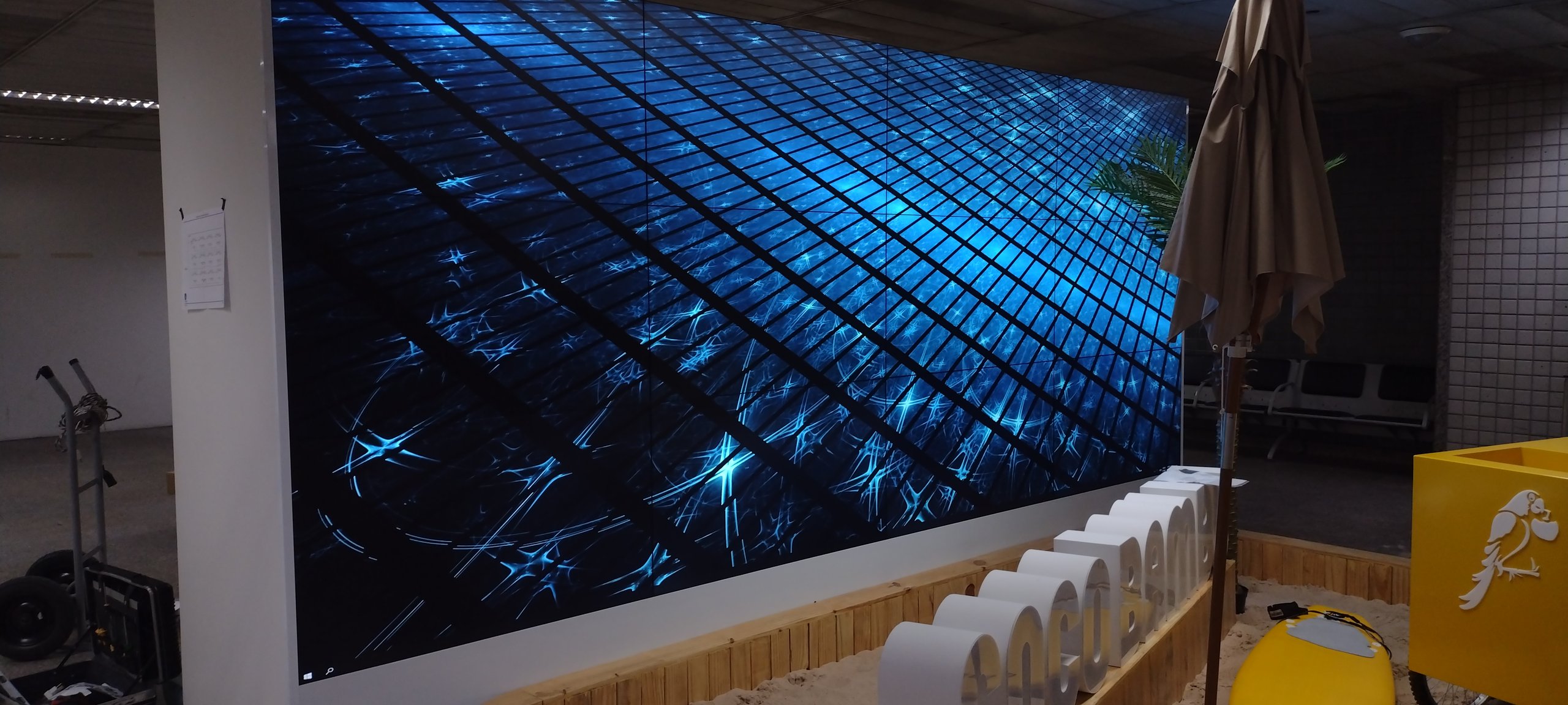 Detalhe em perspectiva do VideoWall 3x4 ligado, mostrando as bordas finas entre os doze monitores
