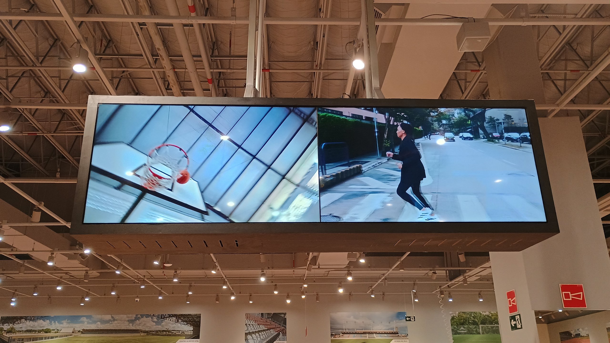 Telas do videowall suspenso com vídeos de esporte na loja Centauro do Pátio Maceió