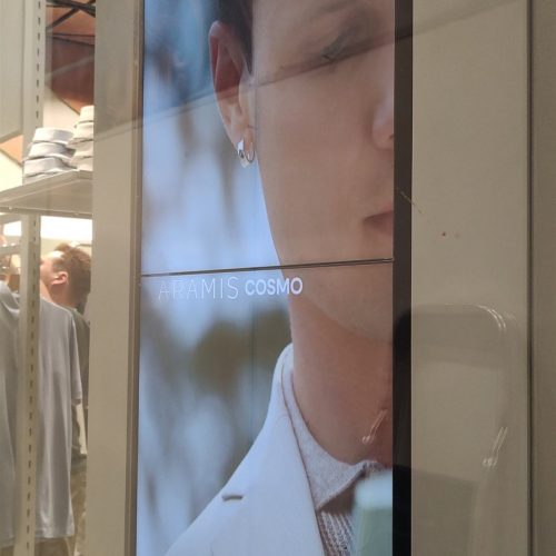 VideoWall vertical com dois monitores LG 49 polegadas exibindo campanha Aramis Cosmo em pilar da loja no Shopping Ibirapuera