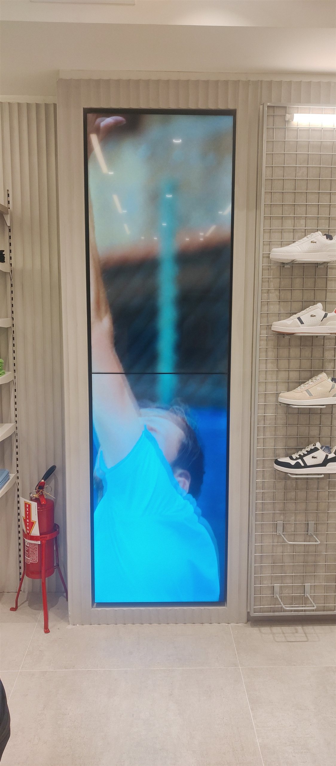 VideoWall vertical com dois monitores LG 49 polegadas empilhados exibindo campanha em loja Lacoste em Florianópolis