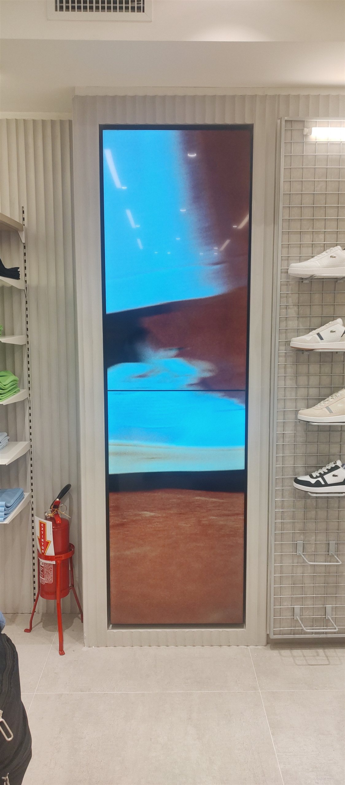 VideoWall vertical 1x2 embutido em nicho exibindo vídeo em loja de moda em Florianópolis